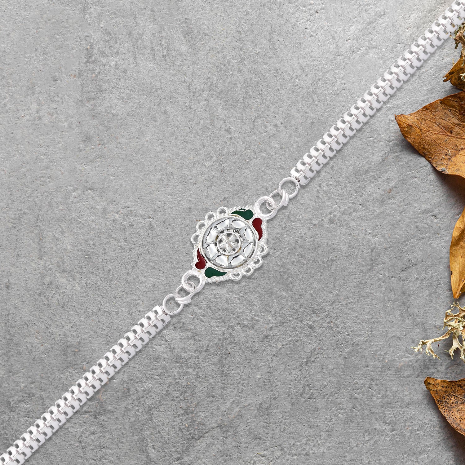 Stylish Rakhi With Intricate Floral Motif And Enamel Touches Stylish Rakhi With Intricate Floral Motif And Enamel Touches